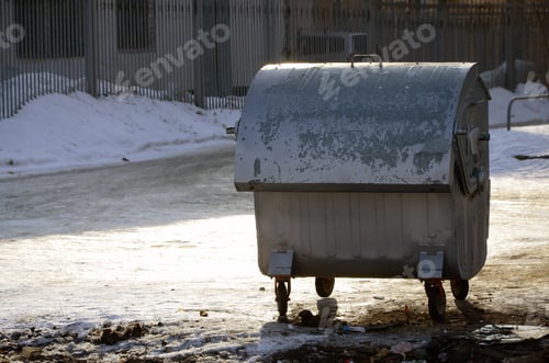Preview: A silver garbage container stands near residential buildings in winter