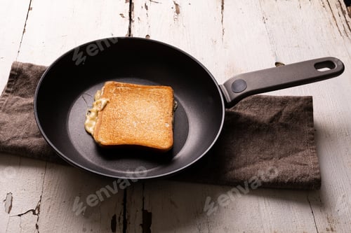 Preview: High angle view of fresh cheese sandwich snack in cooking pan on napkin over white wooden table