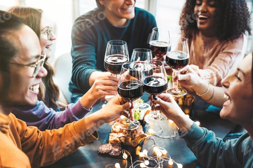 Preview: Multiracial group of friends toasting red wine sitting at bar restaurant table