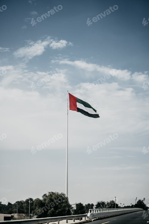 Preview: Beautiful shot of the United Arab Emirates flag Hanging on a white pole under the cloudy sky