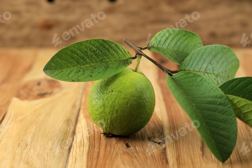 Preview: Fresh Picked Guava and Leaves (Jambu Biji Merah) or Psidium guajava, Isolated on Wooden Table.
