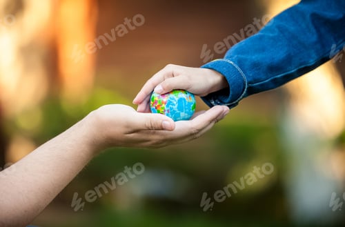 Preview: men hand and little girl hands holding planet Earth