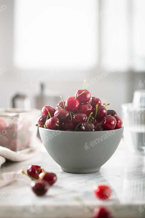 Preview: Cherries on white table prepared for breakfast