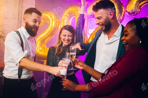 Preview: Multiracial friends celebrating new years eve and pouring champagne at midnight