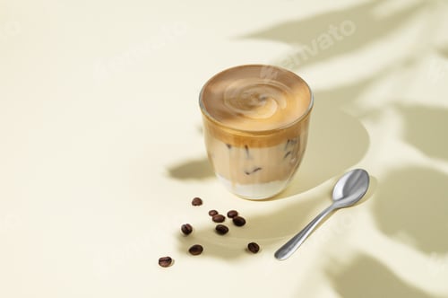 Preview: Iced dalgona coffee. Whipped instant coffee in a glass with ice on a yellow background