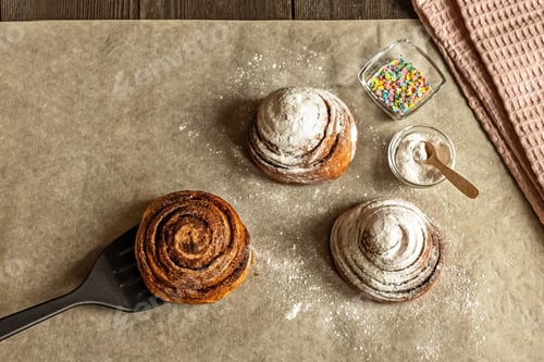 Preview: Freshly baked cinnamon pastry buns, sprinkled with powdered sugar and pastry topping