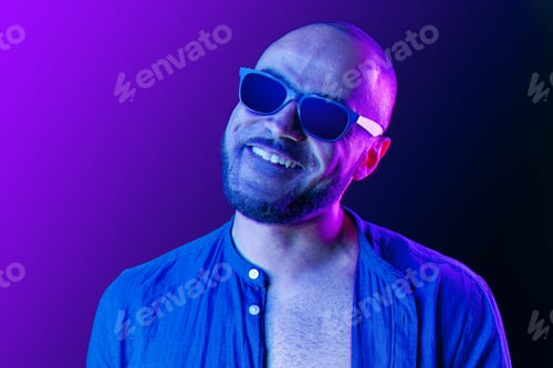 Preview: Portrait of afro american man model in glasses in neon light