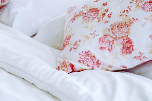 Preview: Bright bedroom interior with flower pattern pillows on bed