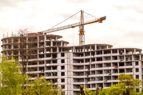 Preview: Modern building under construction against blue sky. Construction work site