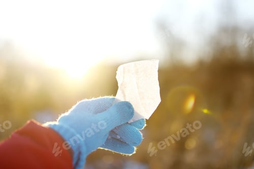 Preview: Girl having fun playing with icicle on sunny winter day. Person looking through ice at sun.