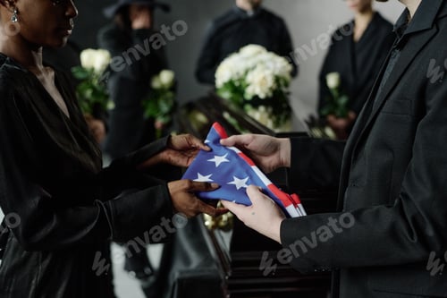 Preview: Caucasian Man Handing Folded American Flag to Black Woman at Funeral Ceremony