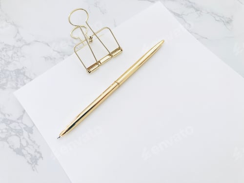 Preview: Blank white paper with gold pen on white marble desk