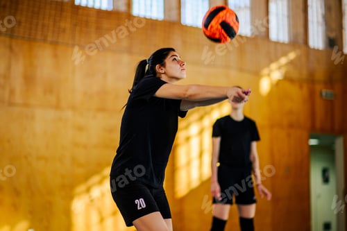 Preview: A teenage volleyball player is hitting a ball on court on training.