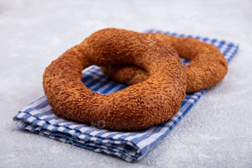 Preview: side view of delicious and soft traditional turkish bagels isolated on a checked cloth on a white