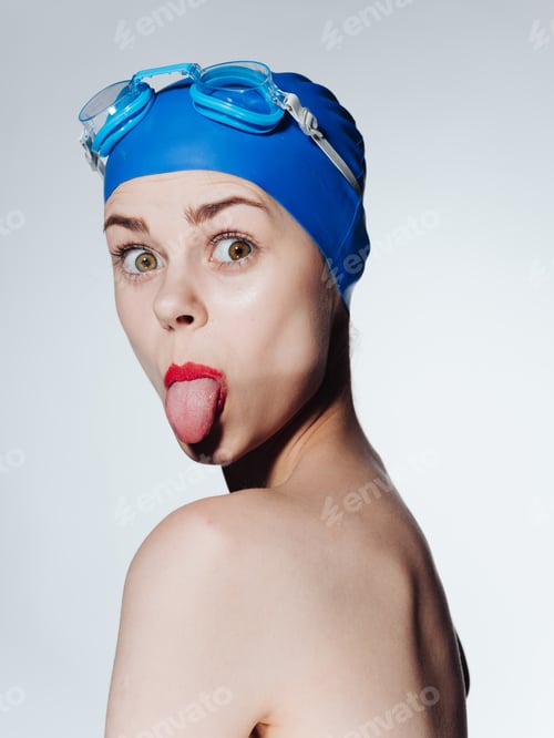Preview: Emotional woman in a cap for swimming on a light background close-up portrait
