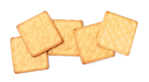 Preview: Many crispy crackers isolated on white, top view. Delicious snack