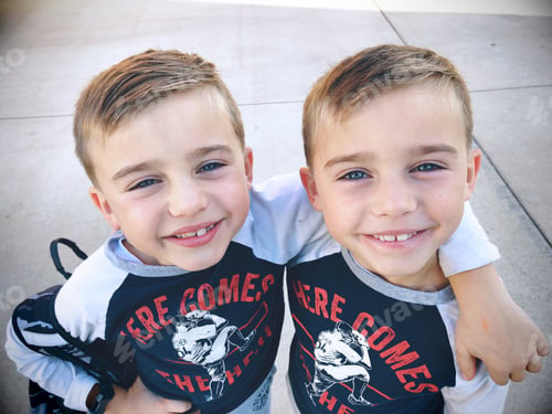 Vista previa: Niños gemelos idénticos sonriendo a la cámara después del corte de pelo