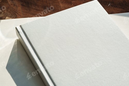 Preview: Books by the window on wooden background in sunlight