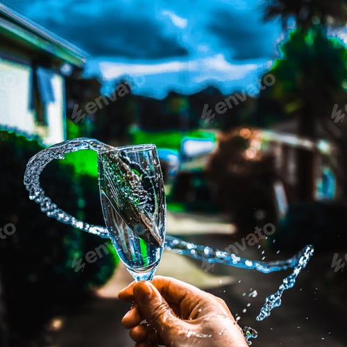 Preview: Closeup of a female hand spilling water in a garden