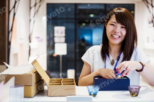Preview: Saleswoman in a shop selling Edo Kiriko cut glass in Tokyo, Japan.