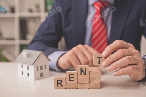Preview: cropped view of agent holding wooden cube with lettering near carton house model