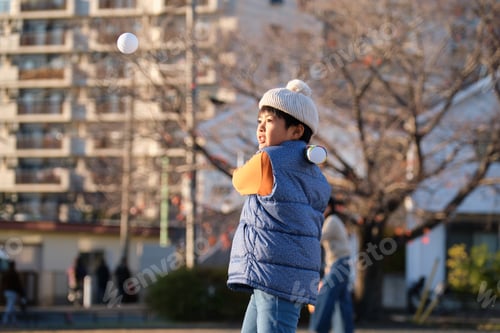 Preview: Japanese boy playing baseball with bat and ball in park