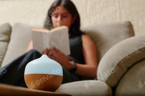 Preview: Young Latina woman reads a book while using aromatherapy.