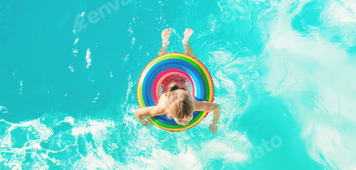 Preview: A child swims in a swimming pool with a life preserver. Selective focus.