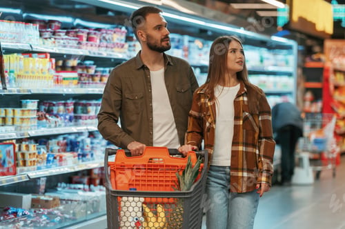Preview: Choosing the products. Young couple are in supermarket together
