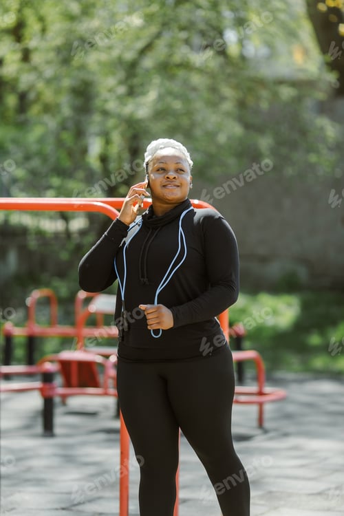 Preview: Afro-american plus size woman doing workout exercises session outdoor