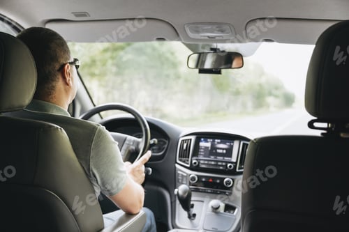 Preview: Young man holding steering wheel while driving car. Road trip adventure