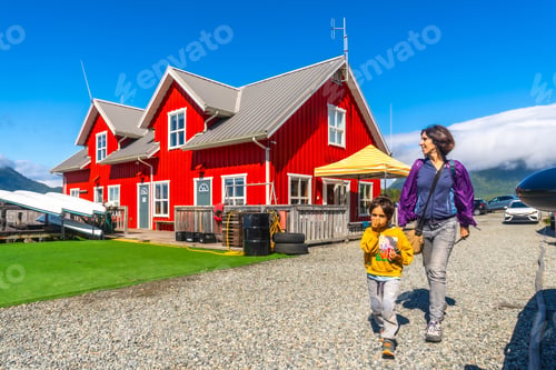 Preview: Mother and child walking near red building in tofino, vancouver island