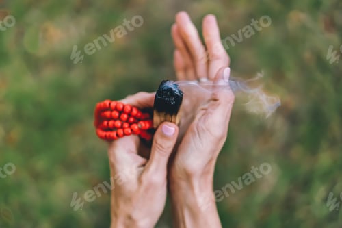 Preview: Top angle view of a palo santo or a holy sacred tree stick, burning with aroma smoke