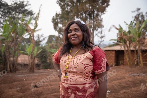 Preview: portrait of a 50 year old African woman well dressed in an African dress outdoors.