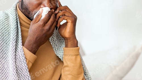Preview: Afro Guy Blowing Nose In Napkin Sitting On Sofa Indoor