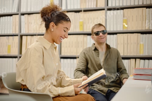 Preview: Young Man with Visual Impairment Sitting with Young Woman Reading Book