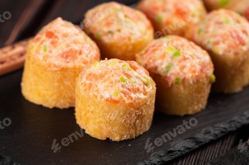 Preview: Sushi roll with mayonnaise sauce served on black board and soy sauce close-up