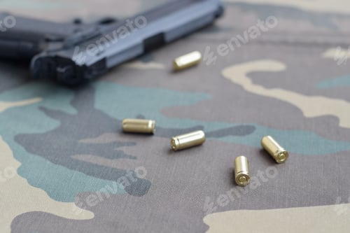 Preview: 9mm bullets and pistol lie on camouflage green fabric