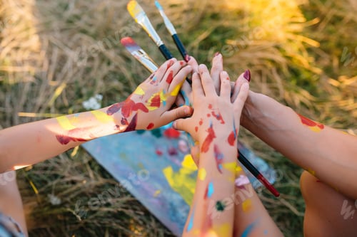Vista previa: mother teaches daughter paint in park. Sunny nature, mom and daughter paint a picture