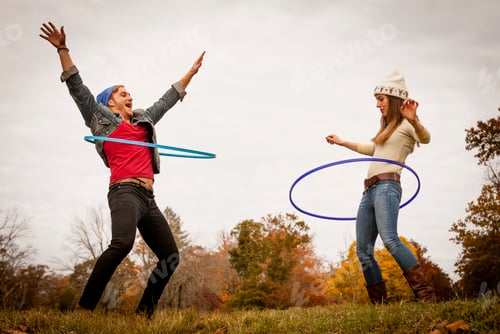 Preview: Young couple playing with plastic hoops in autumn park