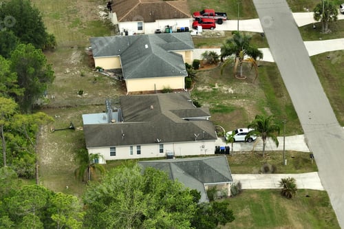 Preview: Aerial view of suburban landscape with private homes between green palm trees