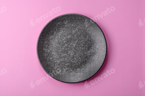 Preview: An empty round ceramic plate on a pink background as a kitchen utensil. An empty plate
