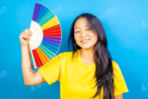 Preview: Chinese woman using a rainbow colored folding fan