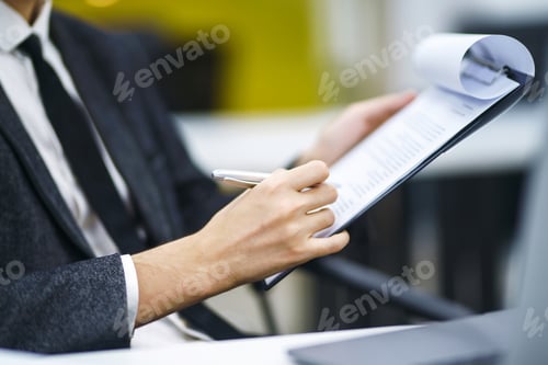 Preview: A man signs a contrac, legal or business agreements. Male hand with pen makes notes.