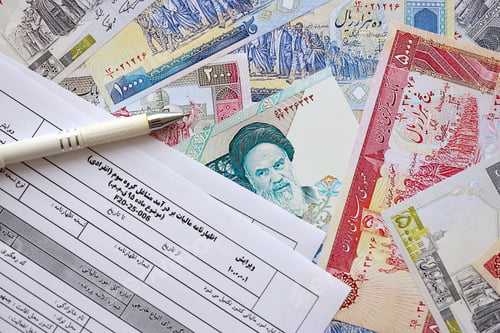 Preview: Iranian annual income tax return form F20-25-006 ready to fill on table with iranian money