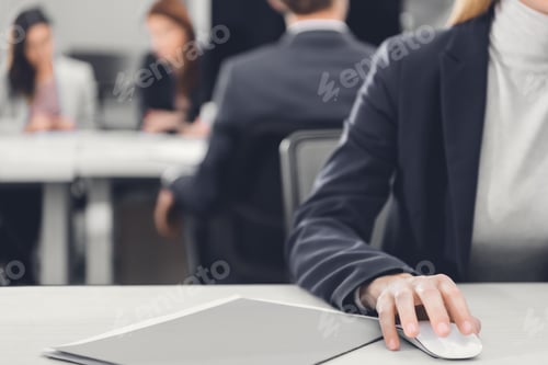 Preview: cropped shot of businesswoman sitting at workplace and using computer mouse