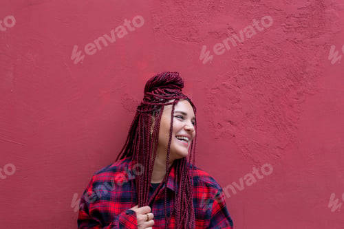 Preview: candid portrait of happy woman with dreadlocks in red shirt on bright background