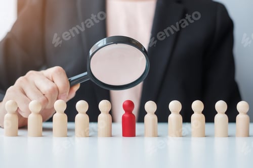 Preview: Businesswoman hand holding magnifying glass for recruiting leader man wooden from crowd of employees