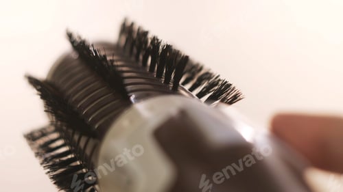 Preview: Girl holding a volumebrush for hair straightening isolated on white background. Concept. Woman hand