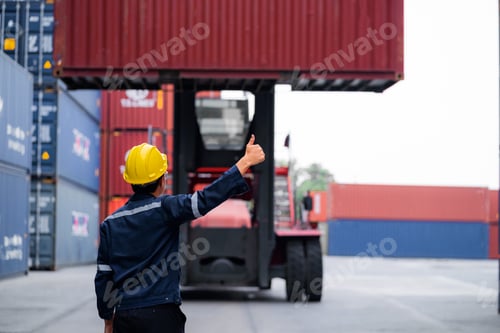 Preview: A man wearing a yellow helmet is giving a thumbs up to a truck